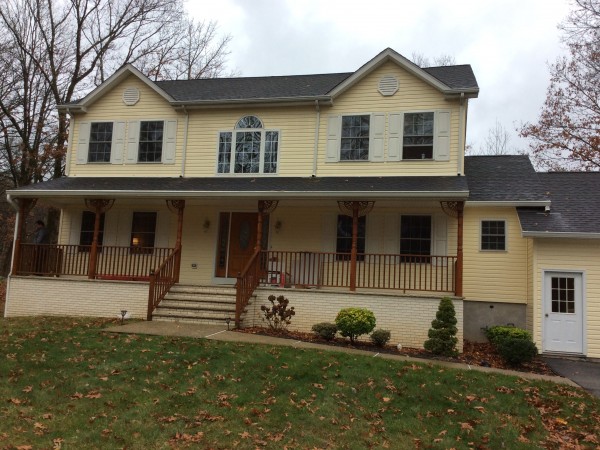 Finished two-story home with a new front porch, railings and siding