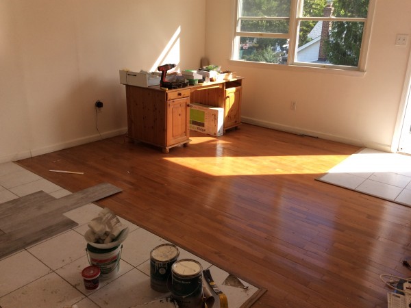 Hardwood and tile flooring being installed in a bright living space